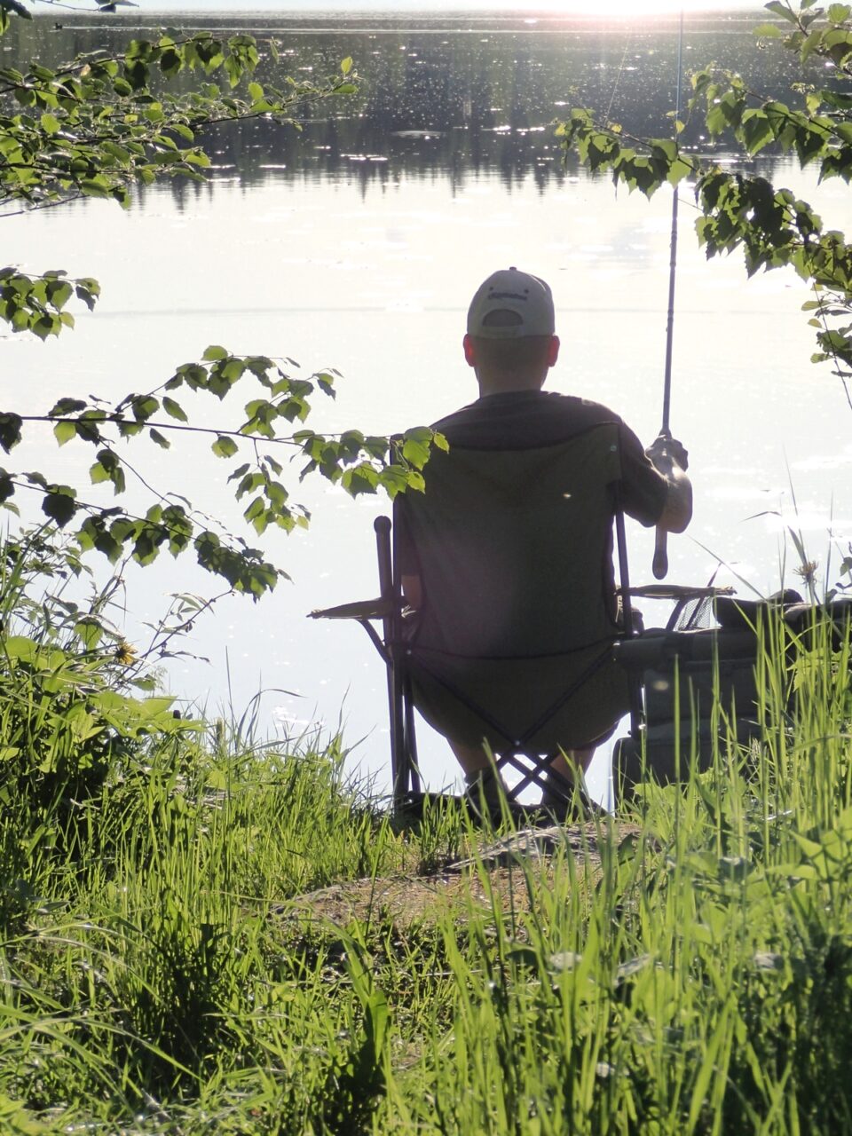 Mies rannassa onkimassa kelaongella